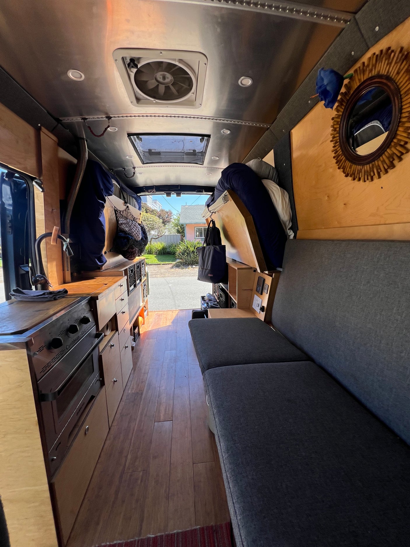 Inside a modern rv rental: a compact kitchen, comfortable grey sofa, and clever storage for mobile adventures.