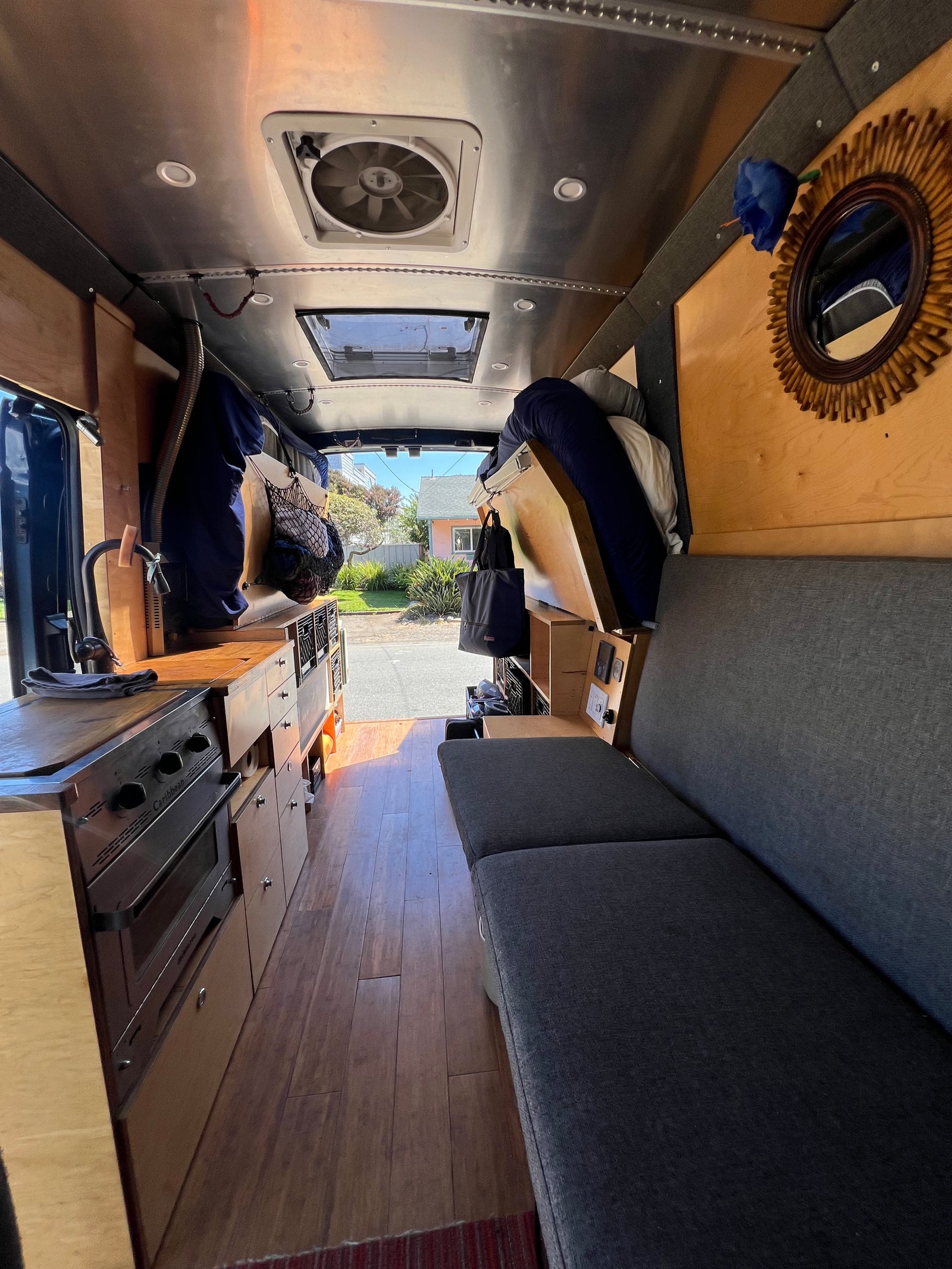 Inside a modern rv rental: a compact kitchen, comfortable grey sofa, and clever storage for mobile adventures.