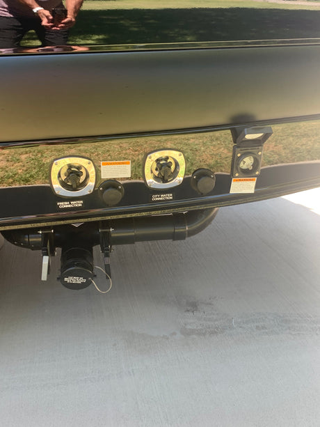 RV rental utility panel showing fresh/city water connections, 30-amp electrical hookup, and waste dump valves below.