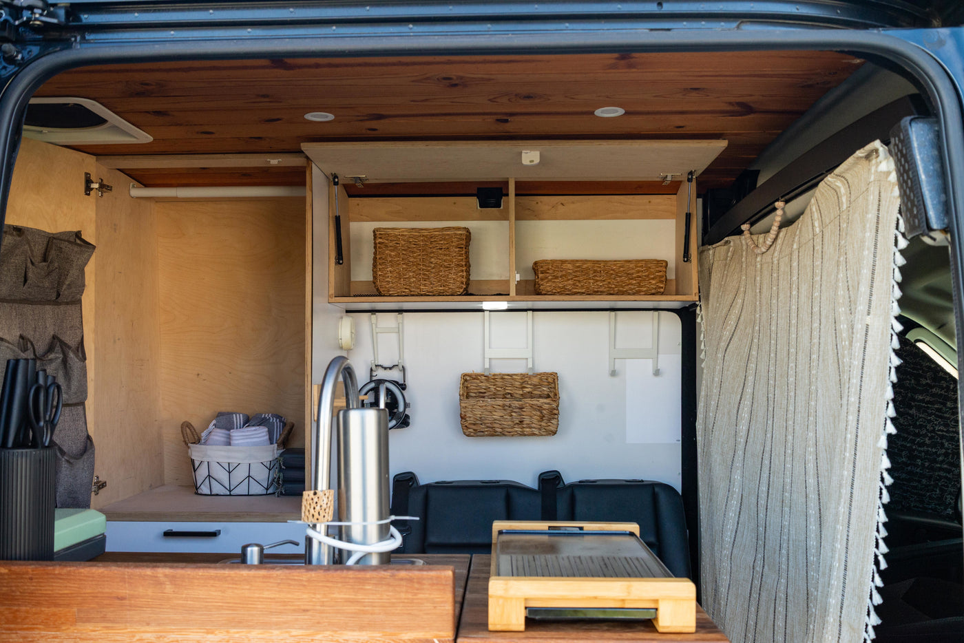 This RV rental interior showcases a compact kitchen, smart storage solutions, and wooden accents, perfect for adventurous travel. — photo 10