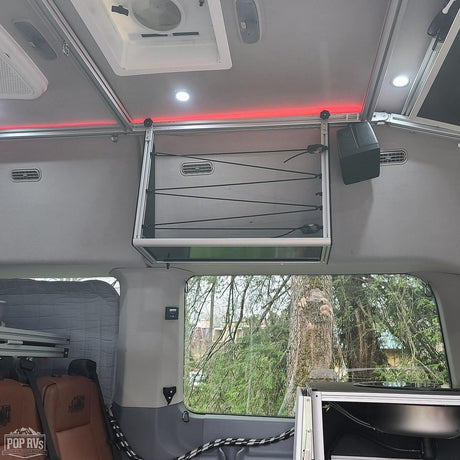 Explore this RV rental's organized interior: overhead storage with bungee cords, bright and ambient lighting for comfortable travel.