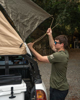 Preparing the rooftop tent on a truck for a camping trip. Perfect for your next outdoor **RV rental** adventure.