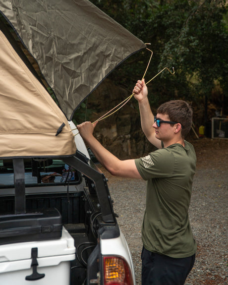 Preparing the rooftop tent on a truck for a camping trip. Perfect for your next outdoor **RV rental** adventure.