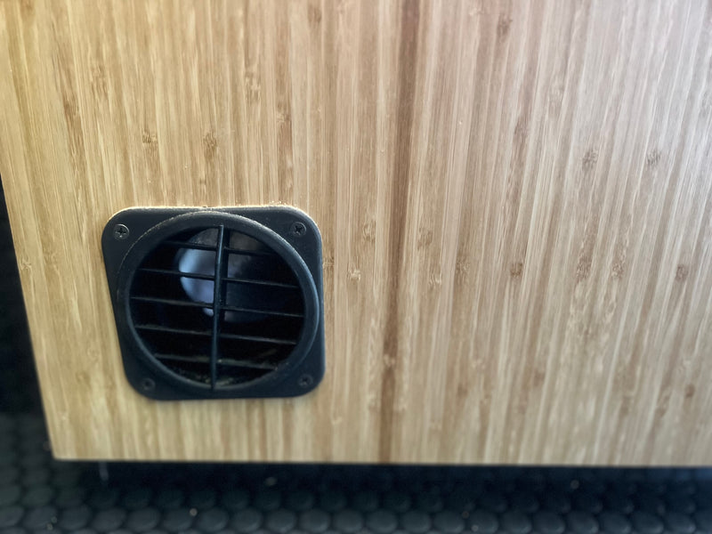 Details of an RV rental: a black ventilation fan and grille mounted on light wood (bamboo) paneling. — photo 17
