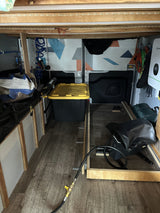 RV rental interior: organized storage with wooden floors, a water heater, and Growatt power system.