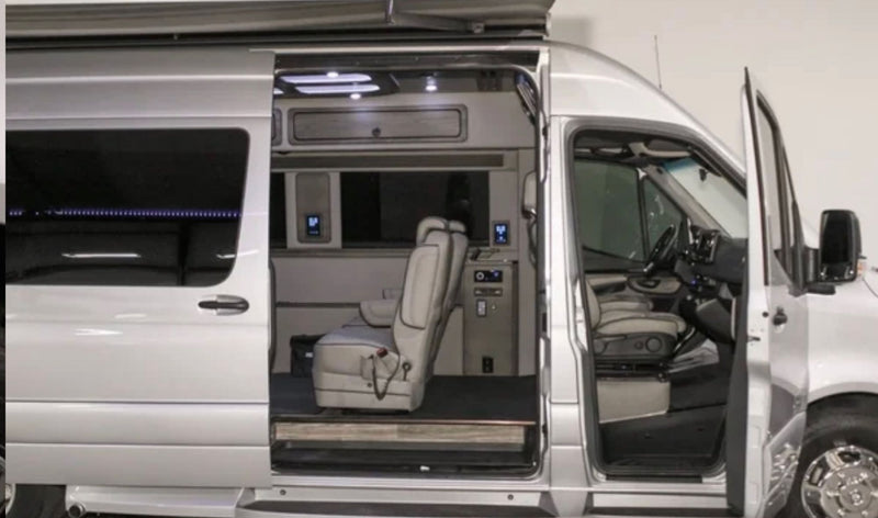 Get a glimpse inside this silver luxury RV rental van! Open doors reveal spacious, custom interior with comfortable seating. — photo 3