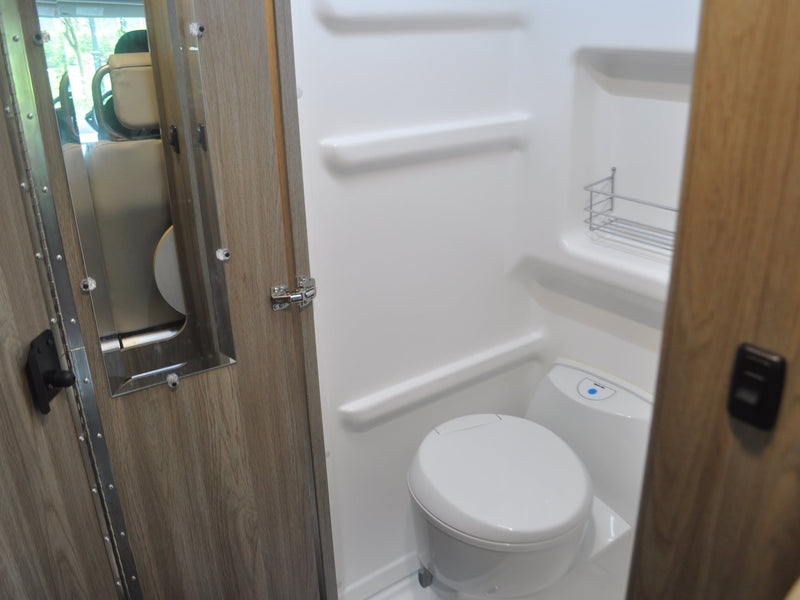  nestled among vibrant flowers and lush green trees.|Open rear of an RV rental camper van — photo 6