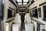 Elegant RV rental interior featuring two cream captain's chairs, dark wood trim, ambient lighting, and comfortable amenities.