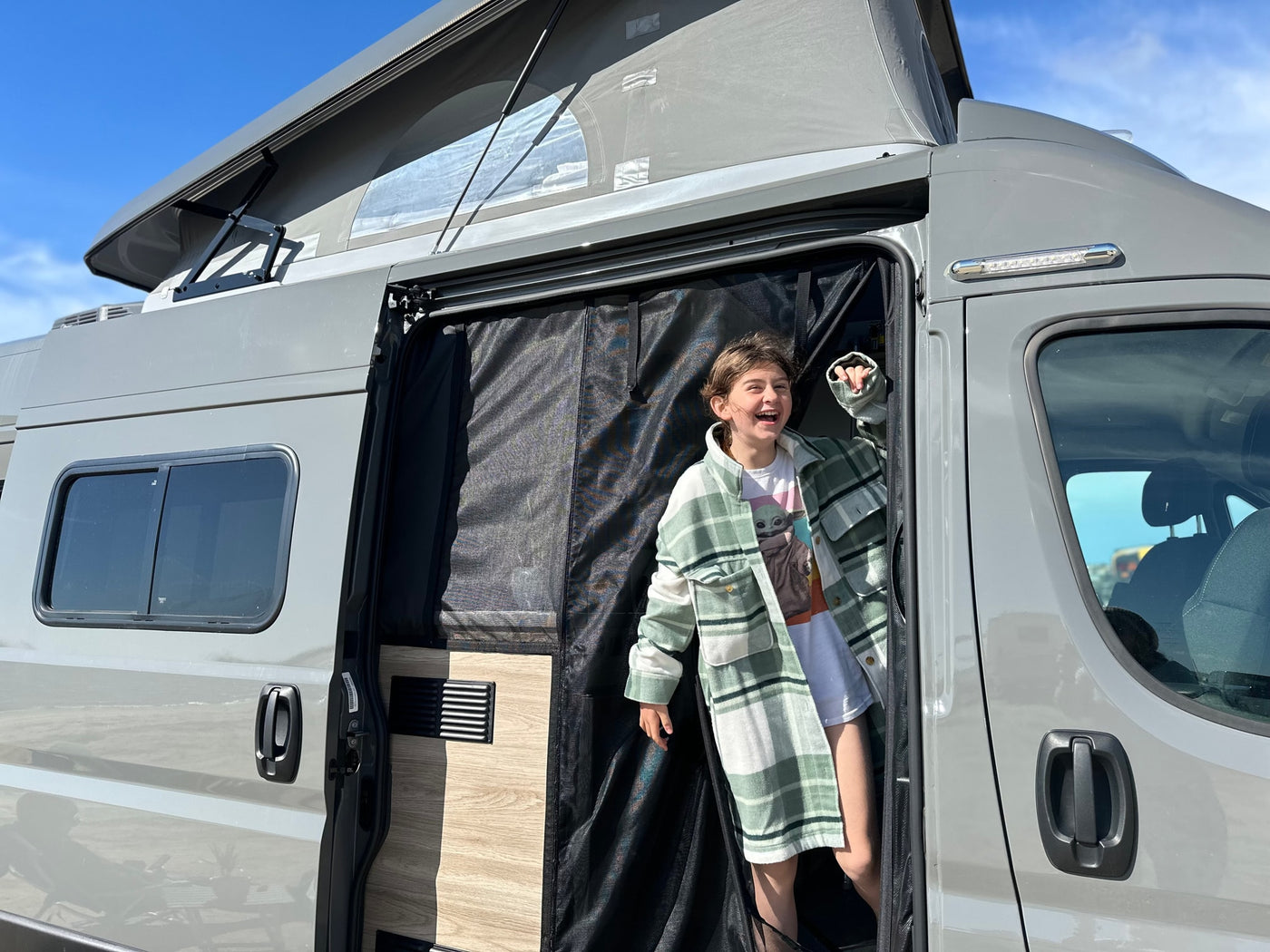  ready for adventure.|Serene rv rental camper van in a vibrant yellow flower field under a bright blue sky. Perfect for outdoor travel.|A grey RV rental is parked by a scenic road — photo 5