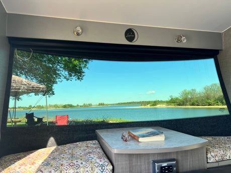  parked in a scenic mountain lot under cloudy skies.|Experience nature with this RV rental! Inside this Luna camper