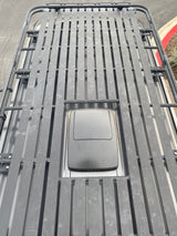 Overhead view of an RV rental roof with a heavy-duty roof rack and a mounted satellite dish for connectivity.