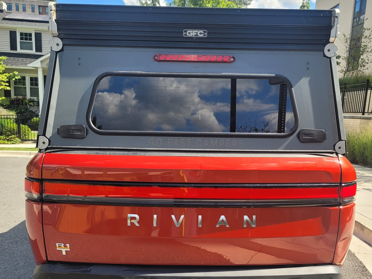  an RV rental alternative for adventures.|A red Rivian R1T electric pickup truck with a GFC camper shell — photo 6