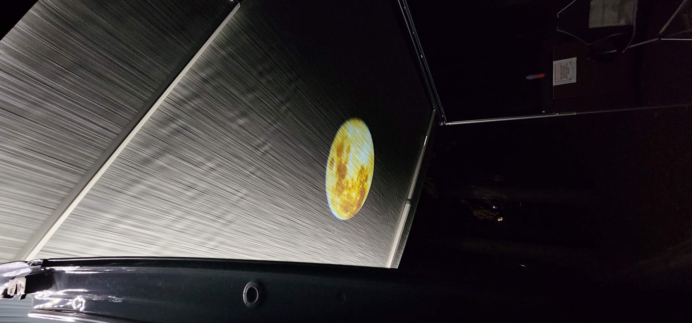 RV rental outdoor cinema: A planet projected onto a large RV awning at night. Great for camping movie nights!