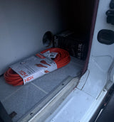 RV rental essentials: An orange extension cord and a NOCO 6.0L gas/3.0L diesel jump starter for vehicle emergencies.
