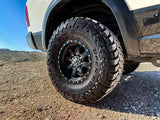 Close-up of a rugged off-road tire on an RV rental truck, ready for desert adventures on rocky terrain.