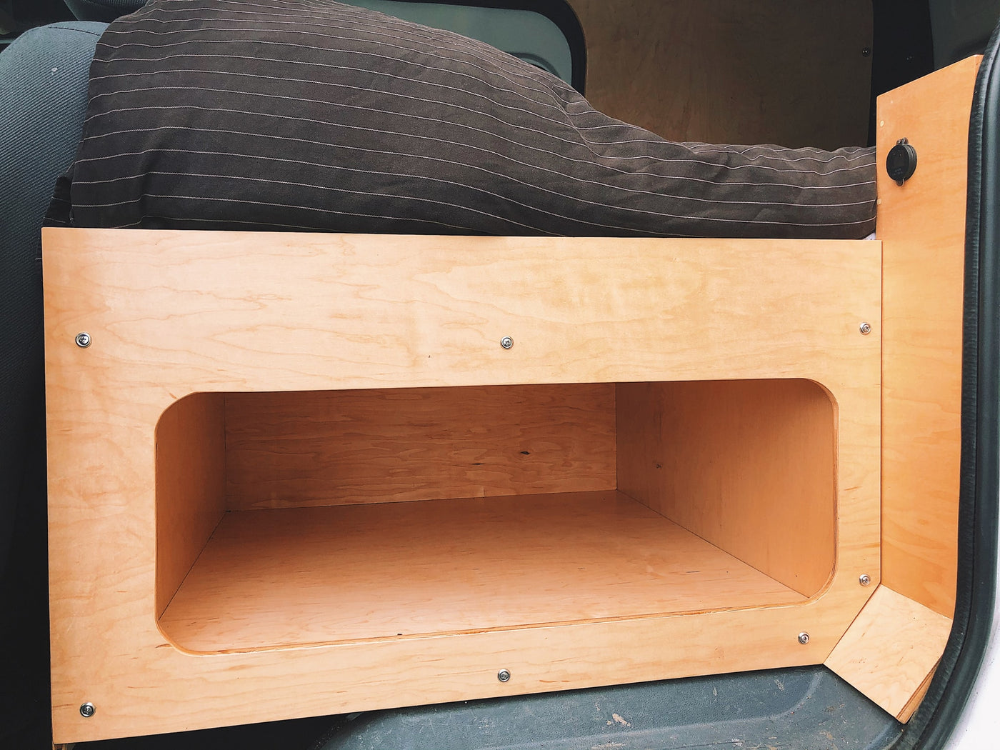  wood-paneled bedroom opening to a serene lake and mountain view.|Inside an RV rental: a portable power station (1500W) on a pull-out tray — photo 10
