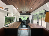 Step inside this modern RV rental with a rich wood plank ceiling, practical counters, and comfortable seating, ideal for travel.