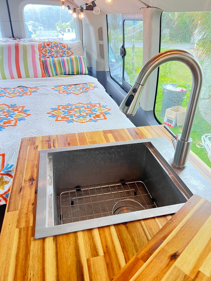  sits amidst lush tropical palms with distant green mountains.|This rv rental features a well-appointed interior with a comfy bed — photo 8