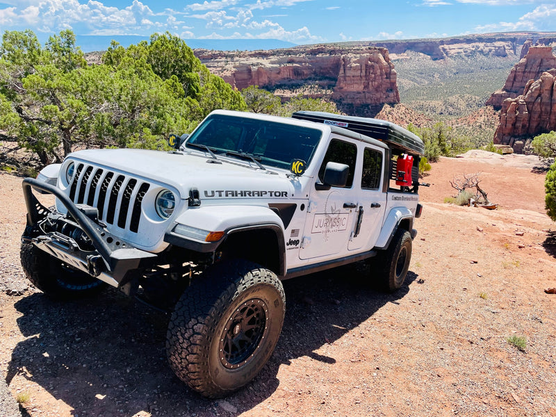 A white Jeep Gladiator custom overland RV rental with a rooftop tent — photo 1