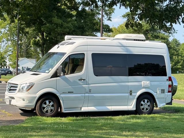 White Mercedes Sprinter rv rental parked on grass