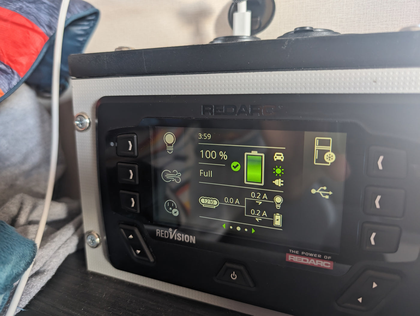 The Redarc RedVision system display shows 100% battery in an RV rental, monitoring power for lights, fridge, and more. — photo 9