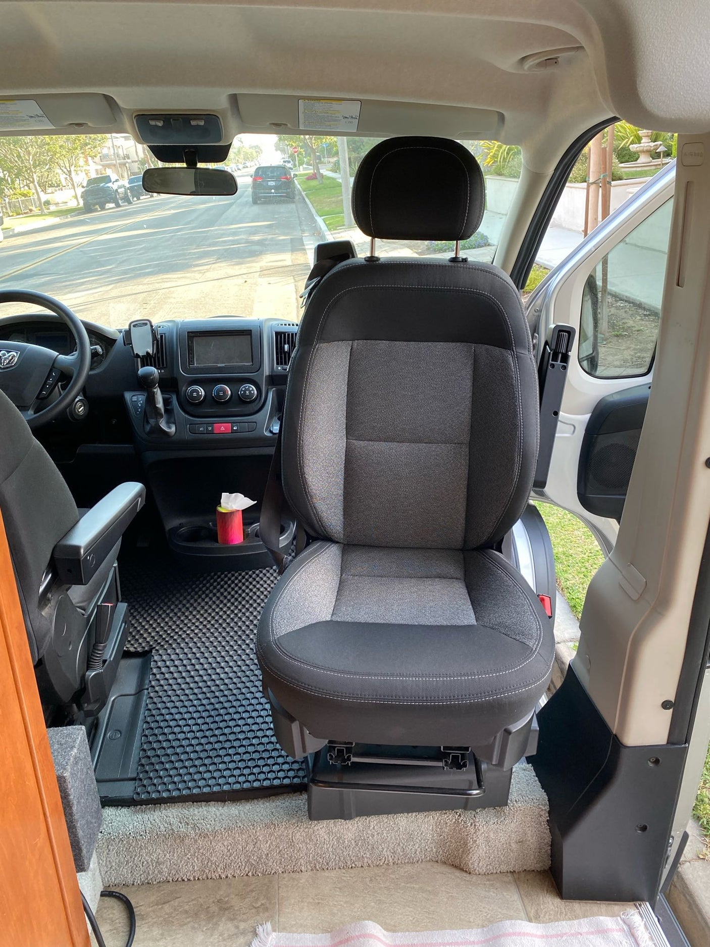 RV rental: Front cabin of a campervan, showcasing the dashboard, driver's seat, and swiveled passenger seat.
