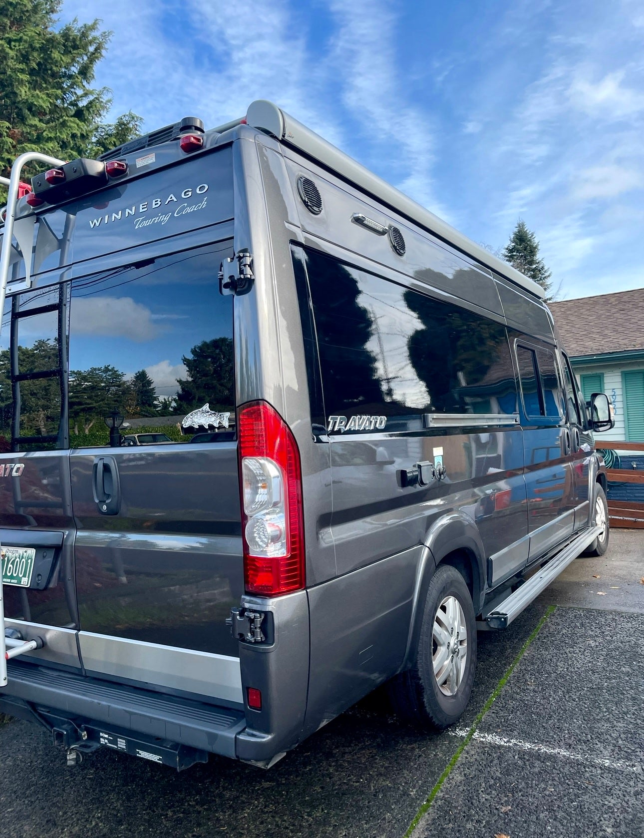 Rear-right view of a modern grey Winnebago Travato RV camper van, excellent for an rv rental.