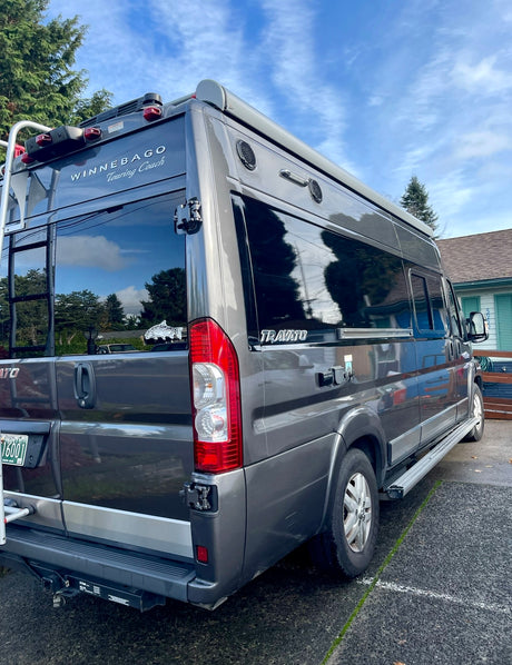 Rear-right view of a modern grey Winnebago Travato RV camper van, excellent for an rv rental.