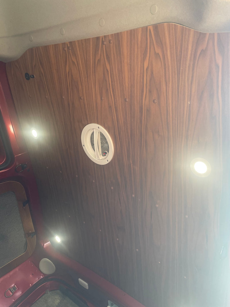 RV rental's wood-paneled ceiling features bright circular LED lights and a central vent, offering a cozy and functional interior. — photo 11
