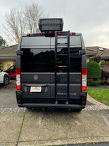 Rear view of a grey camper van with a roof AC unit and ladder, featuring custom branding. Great for an rv rental.