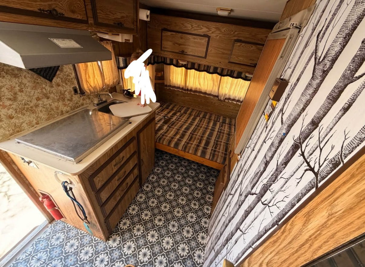  parked outdoors. Perfect for an RV rental adventure or unique stay.|Inside a compact rv rental: kitchenette with stove — photo 4