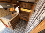  parked outdoors. Perfect for an RV rental adventure or unique stay.|Inside a compact rv rental: kitchenette with stove