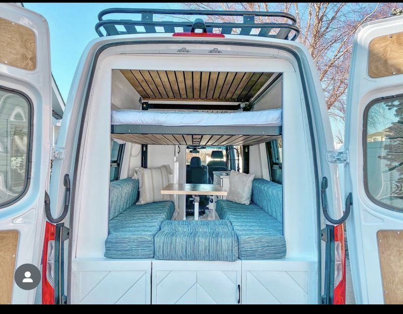  and a crescent moon in the sky.|This RV rental offers a modern camper van interior with a kitchen — photo 2
