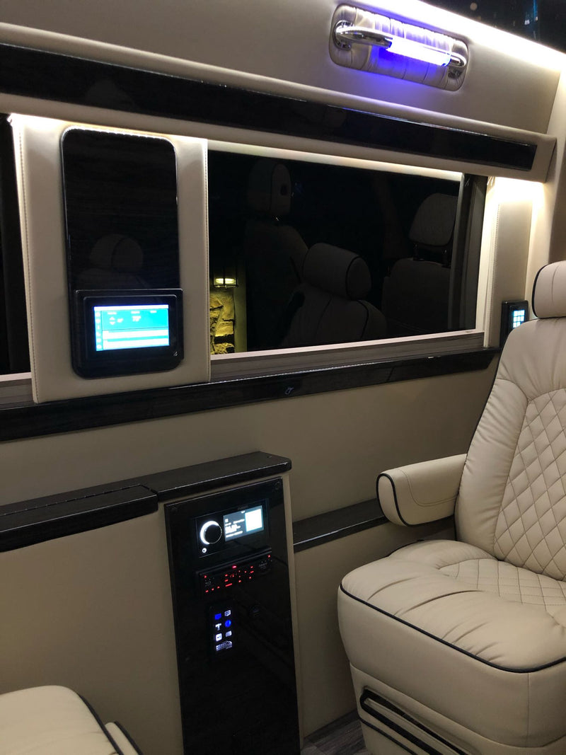 Luxury RV rental interior with cream quilted seats, advanced control panels, and blue accent lighting for ultimate comfort. — photo 18