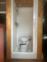 RV rental compact wet bath featuring a composting toilet and shower for efficient mobile living.
