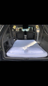 Minivan converted into a cozy sleeper with mattress and pillows. Ideal for car camping, a budget-friendly rv rental alternative.