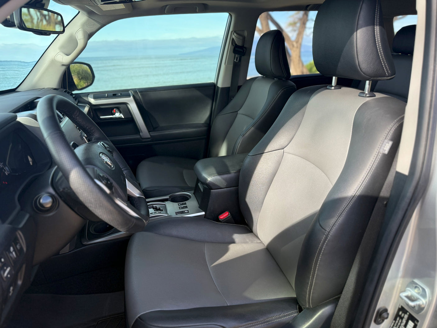 Spacious SUV interior with two-tone seats, steering wheel, and ocean view, ideal for your next rv rental adventure or road trip.