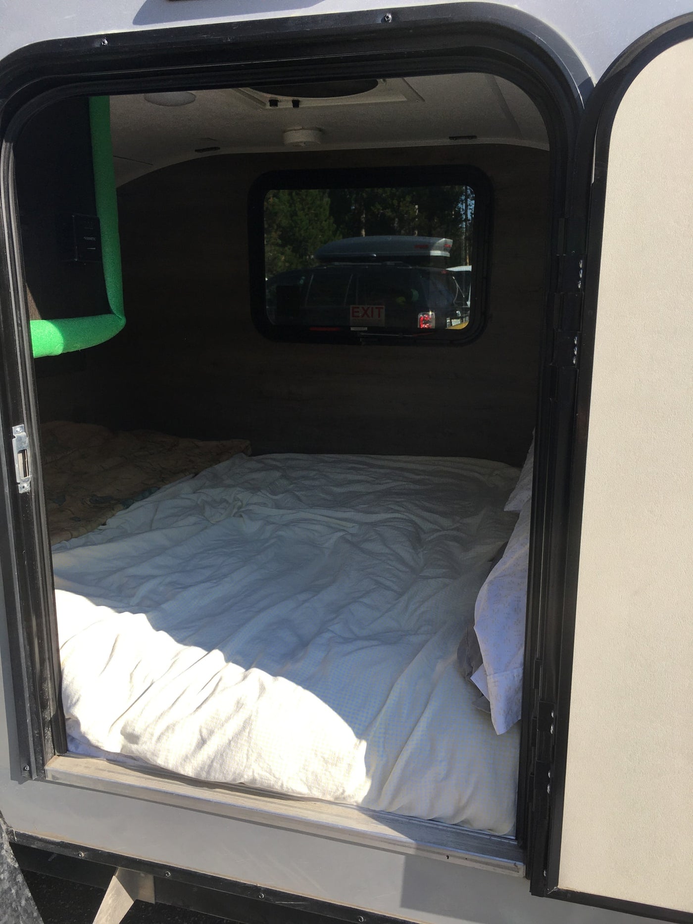Cozy RV rental interior: a comfortable bed fills the sleeping area, viewed through the open door. Perfect for travel. — photo 12