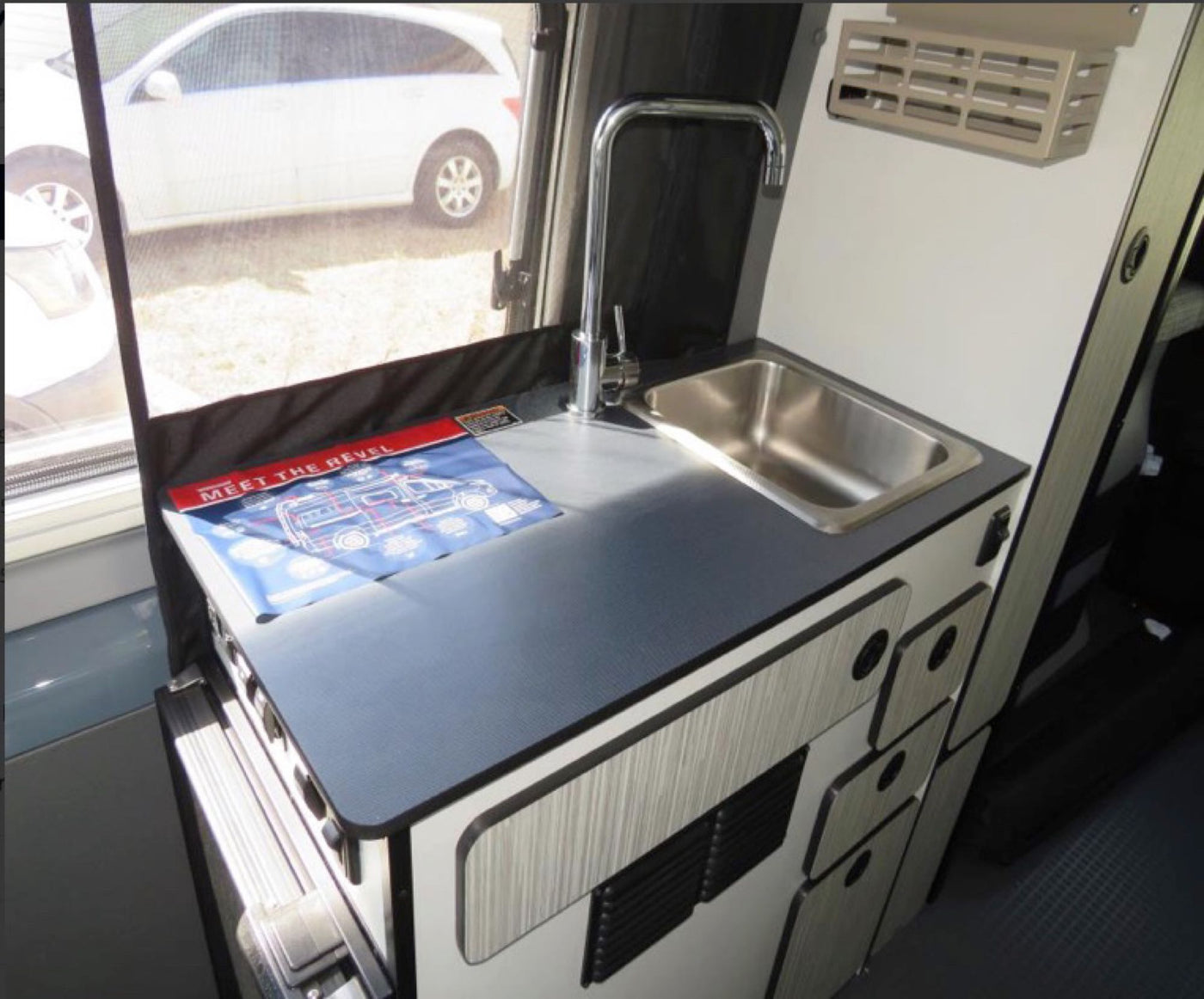  with towering sandstone cliffs & a winding trail. Perfect for your RV rental journey.|Inside an rv rental camper van: compact galley kitchen — photo 9
