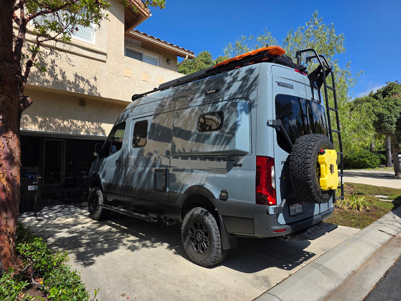 Gray Winnebago Revel 4x4 camper van parked in a sunny driveway. An ideal rv rental for off-road adventure travel. — photo 4