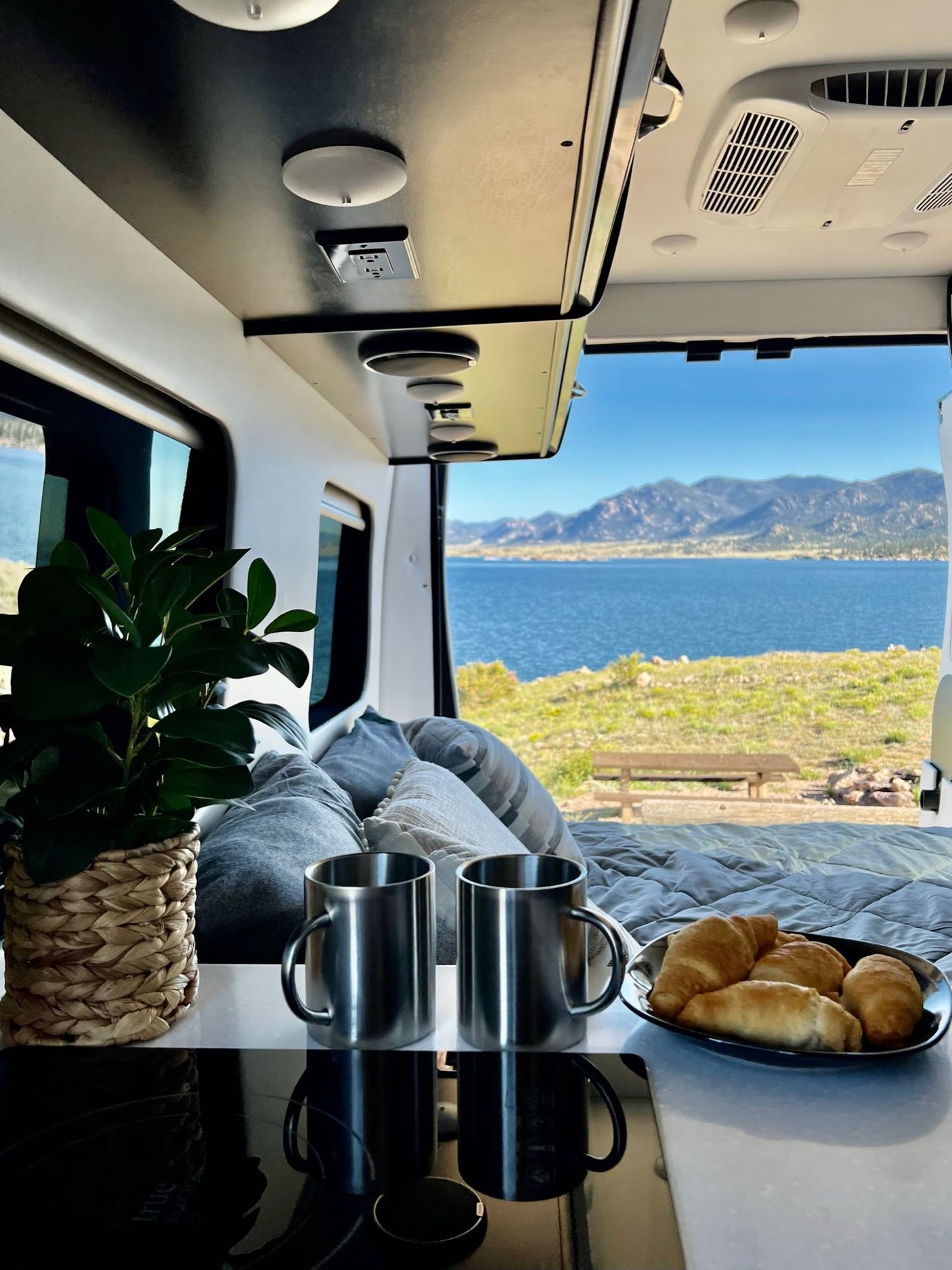 Scenic RV rental: Enjoy lakeside mountain views from your camper van. Coffee & croissants for a perfect morning.