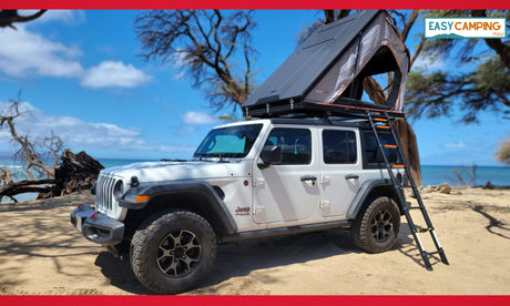 Explore Maui! This RV rental features a white Jeep Wrangler & rooftop tent on a sunny beach, perfect for your next camping adventure.