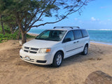 White rental minivan on a Hawaii beach, offering RV rental convenience for island adventures.