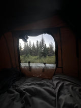 Cozy RV rental view from bed: waking up to a forest sunrise. Enjoy nature's beauty and comfortable camping.