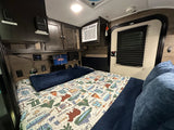 Cozy RV rental interior with a bed, Netflix TV, AC, and controls. Perfect for compact travel and camping adventures.