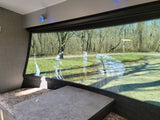 Enjoy the view from your RV rental! Cozy dinette with a large window overlooking a wooded outdoor scene.