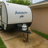 Front view of a white Bushwhacker Plus travel trailer with a propane tank, great for your next RV rental.