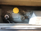 RV rental propane system: Close-up of fill cap, liquid level gauge, vapor valve, and safety warning label.