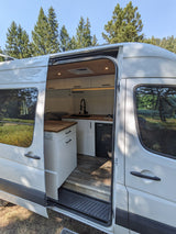 Step inside this modern camper van rv rental, featuring a full kitchen with wood counters & hexagonal tile.