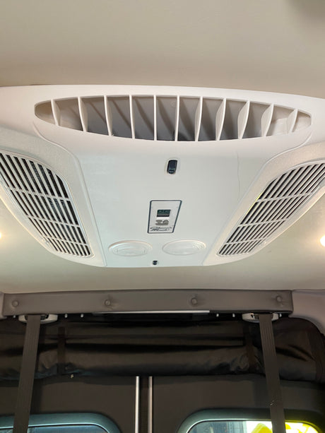 Experience comfort in your rv rental! View of ceiling-mounted Coleman-Mach AC unit with vents & digital controls.